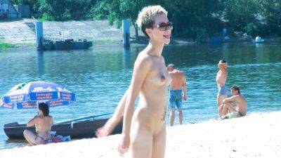 Nude beach girl chats with her friends lays naked and enjoys the sun - hclips.com